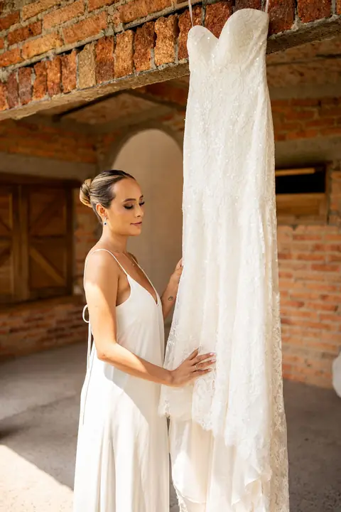 Novia junto a su vestido en una hacienda de ladrillo