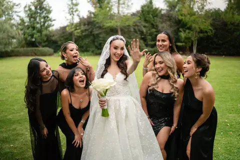 Novia riendo con sus damas en un jardín